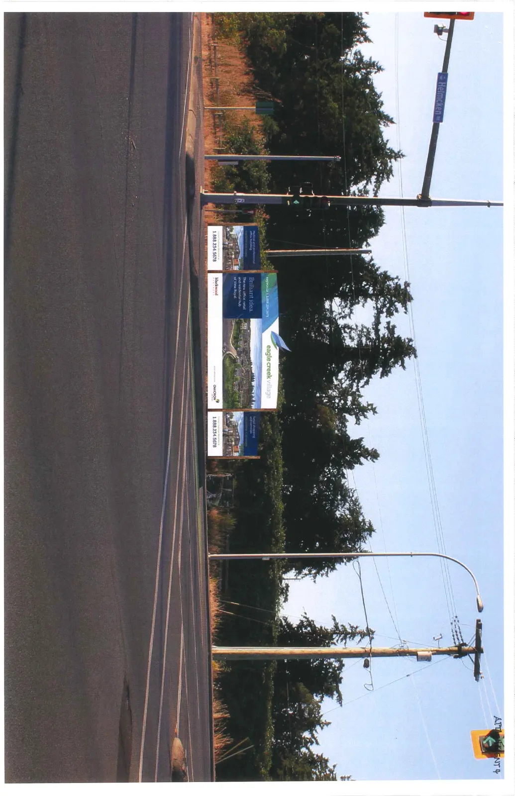 Photographic mockup showing the proposed Eagle Creek Village temporary sign as it would appear in its location at the corner of the intersection of Watkiss Way and Helmcken Road.