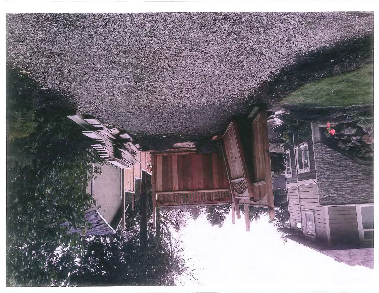 Photograph of the wooden fence panels viewed from the gravel driveway.