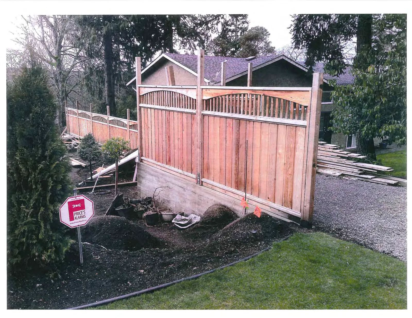 Photograph of the wooden fence sections installed on a concrete retaining wall.