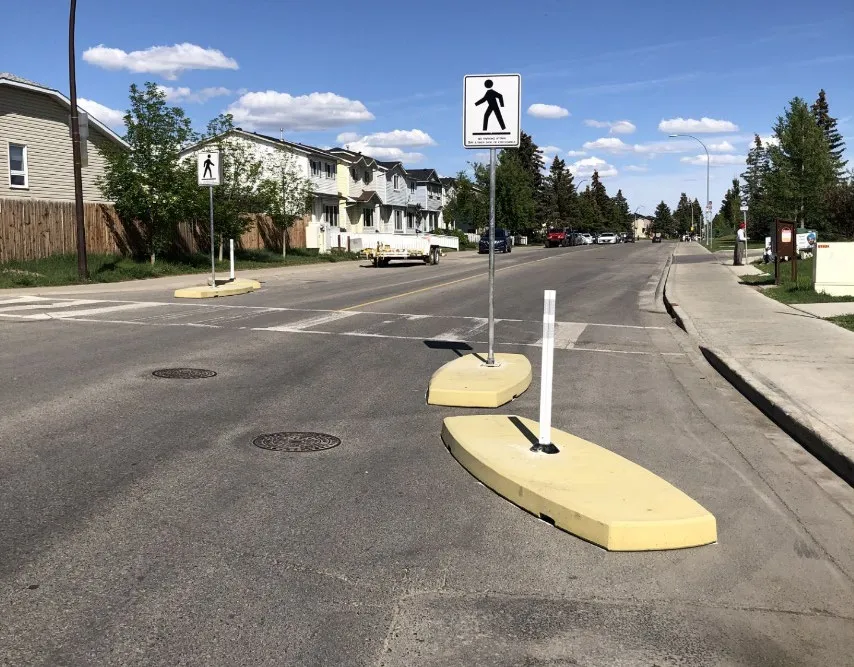Example ‘Calgary Curb’ photo showing temporary traffic control curbs with flexible sign posts on a residential street
