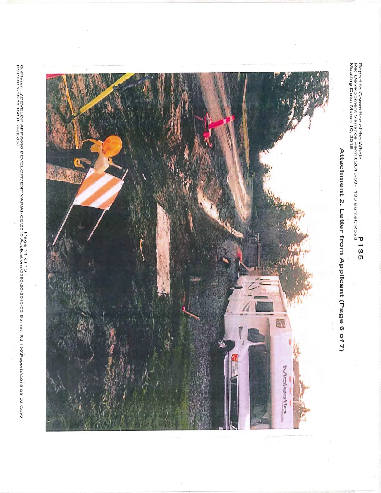 Photo of a muddy construction road with a white motorhome and orange safety markers
