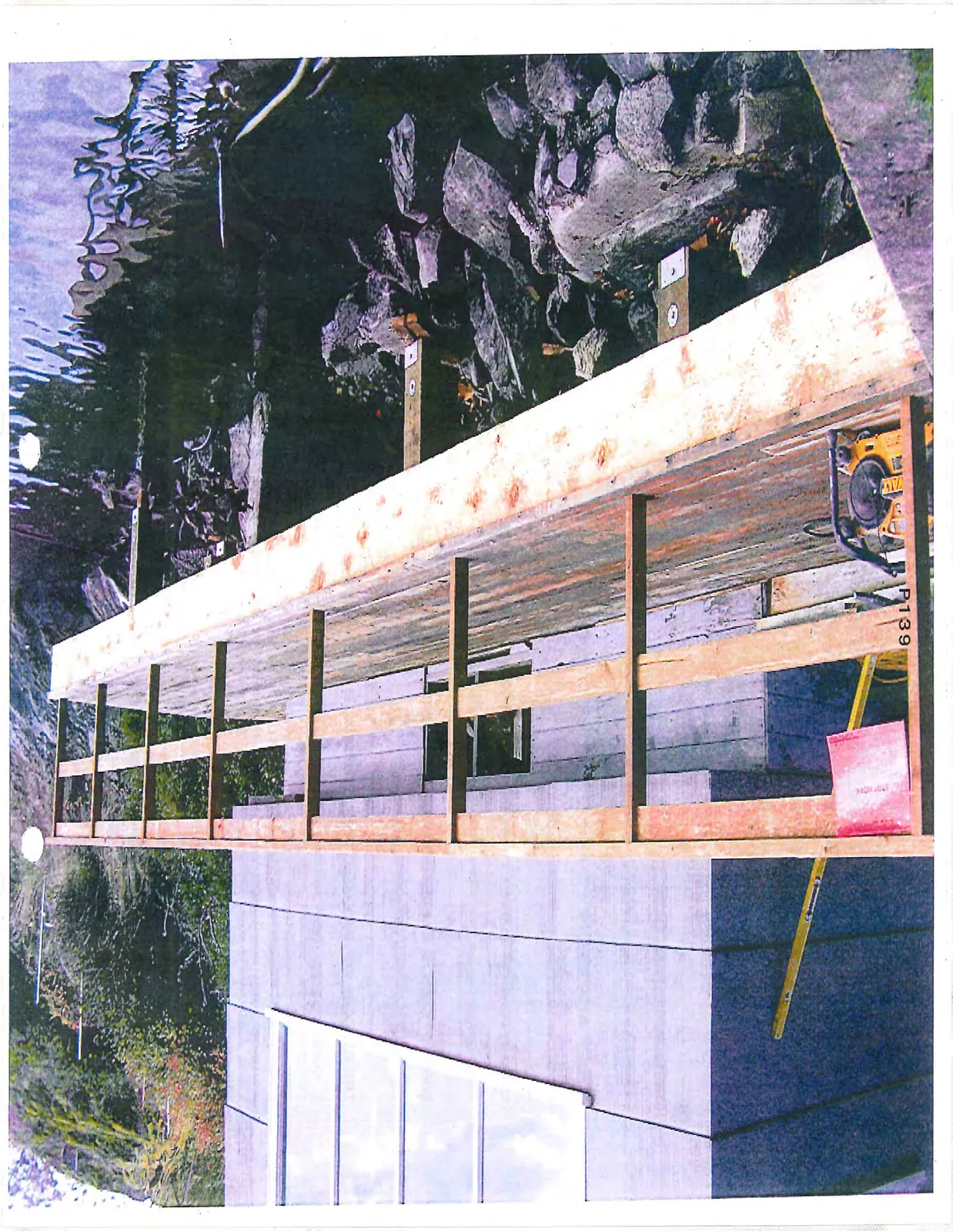 Close-up view of the deck construction project, featuring a red "STOP WORK" notice posted on the railing alongside construction tools.
