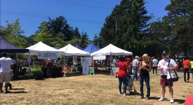 Outdoor community celebration with tents and people at Craigflower Manor