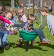 Children playing in a "spinner cup" playground feature