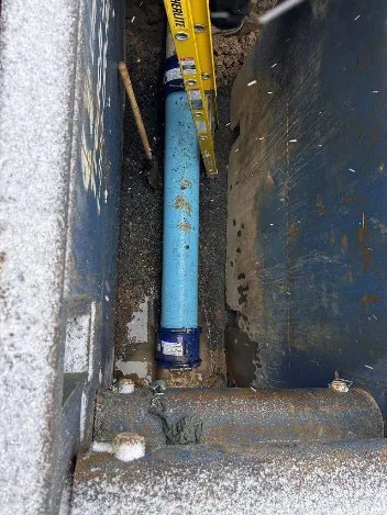 New section of blue pipe installed in the repair trench