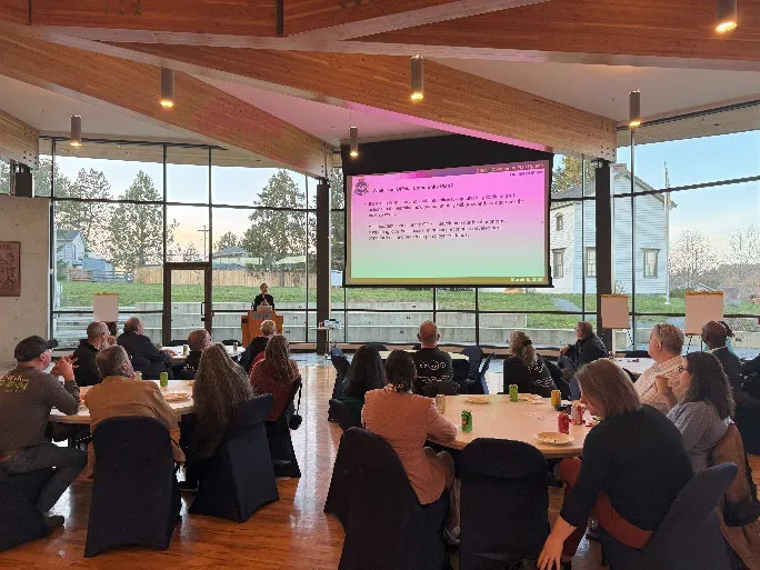 Wide view of the OCP workshop with participants seated at round tables