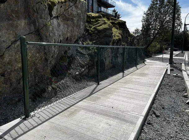 Newly completed concrete sidewalk and perimeter fencing at 9 Erskine frontage