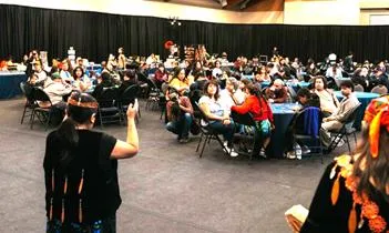 Large group of people seated at round tables for a regional conference