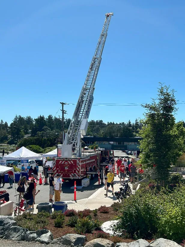View from the lawn to the parking lot featuring a fire truck with an extended aerial ladder