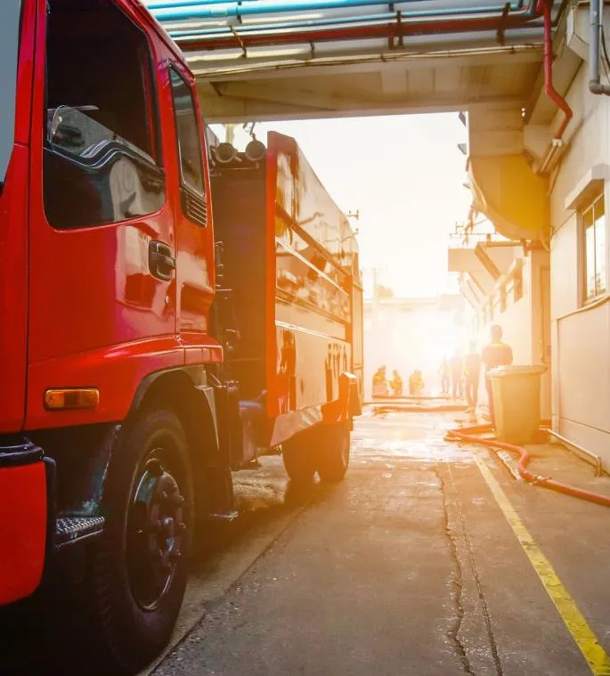 Side view of a red fire truck or service vehicle in a warehouse/bay area