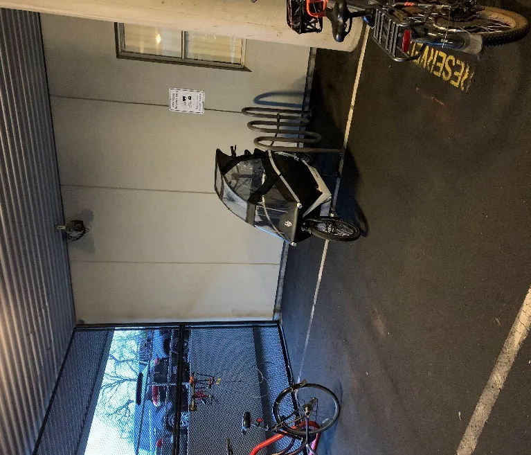 Photo example of a non-standard bike parking space at Royal Jubilee Hospital, showing a cargo bike with a weather cover parked in a dedicated area