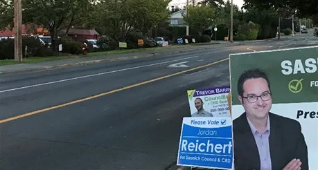 Photograph of various election campaign signs placed at a street corner