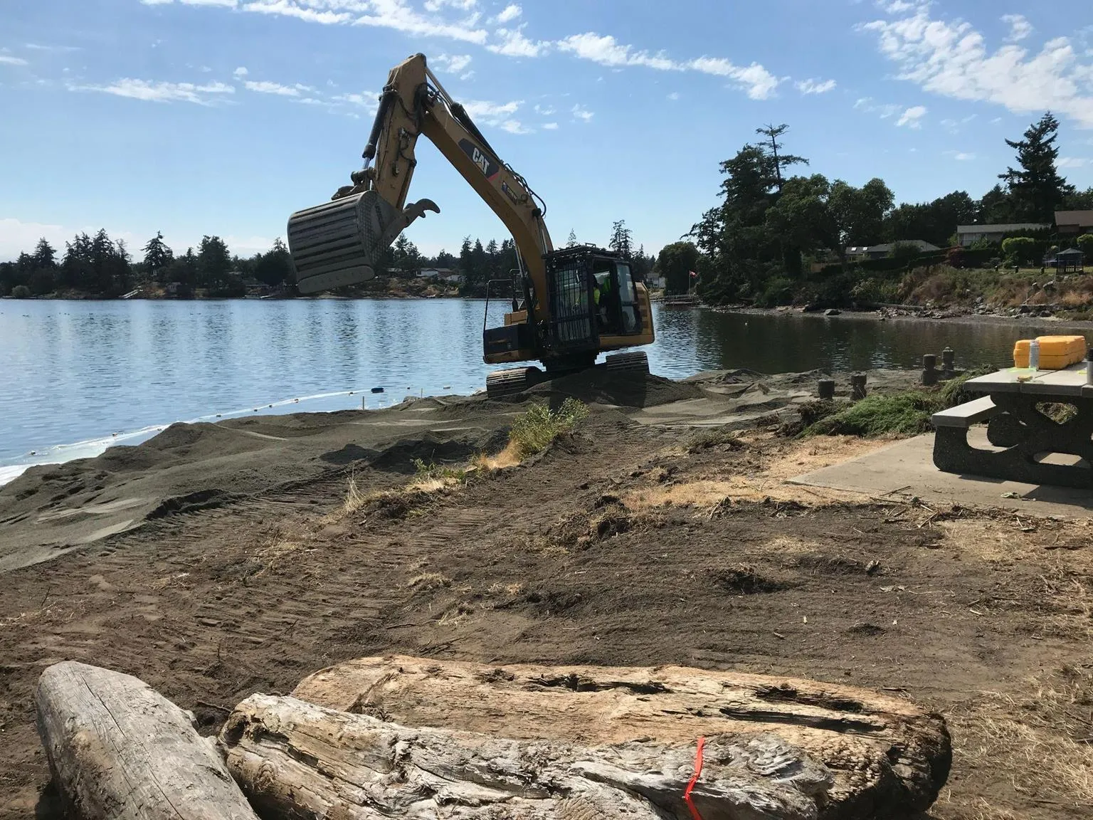 An excavator performing beach nourishment work on the Portage Inlet shoreline.