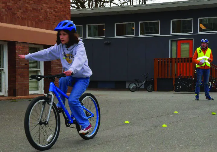 Students practice hand signals. For many students this age, taking their hand off their handlebar is a new skill.