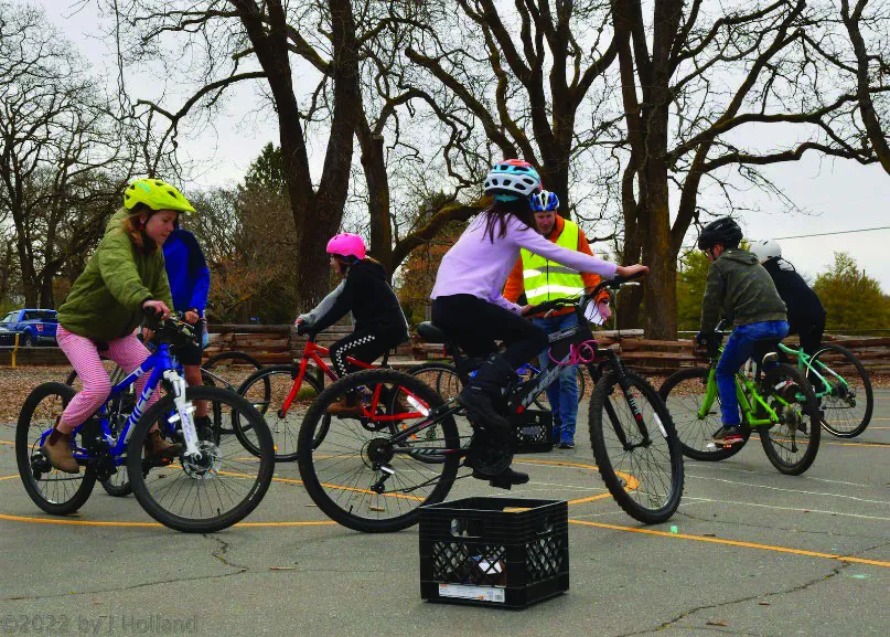 Students compete in a "foot down derby" to see who can bike slowest without putting their foot down, in order to practice better bike handling.