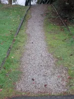 View of the aggregate path with grass and weeds encroaching into the footprint