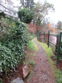 Stone-paved landing area and railing at the edge of the water