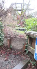 Close-up of the makeshift plywood retaining wall along the staircase