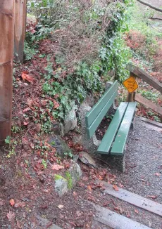 View of the stairs and bench with a yellow "Watch Your Step" sign