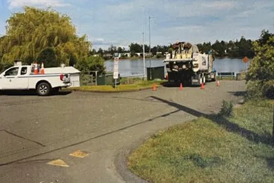 Rear view of a work truck parked near the shoreline