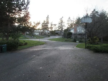 View west from site (Thomas Park Drive) to Werra Road. Site parking on right of photo. Hoop privately owned.