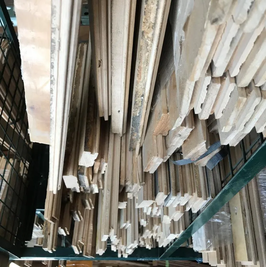 Stacks of salvaged wood flooring and lumber stored on industrial warehouse racking