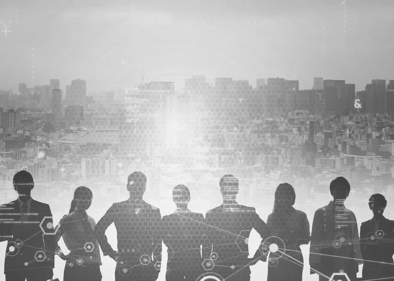 Silhouette of people standing against a digital city skyline background