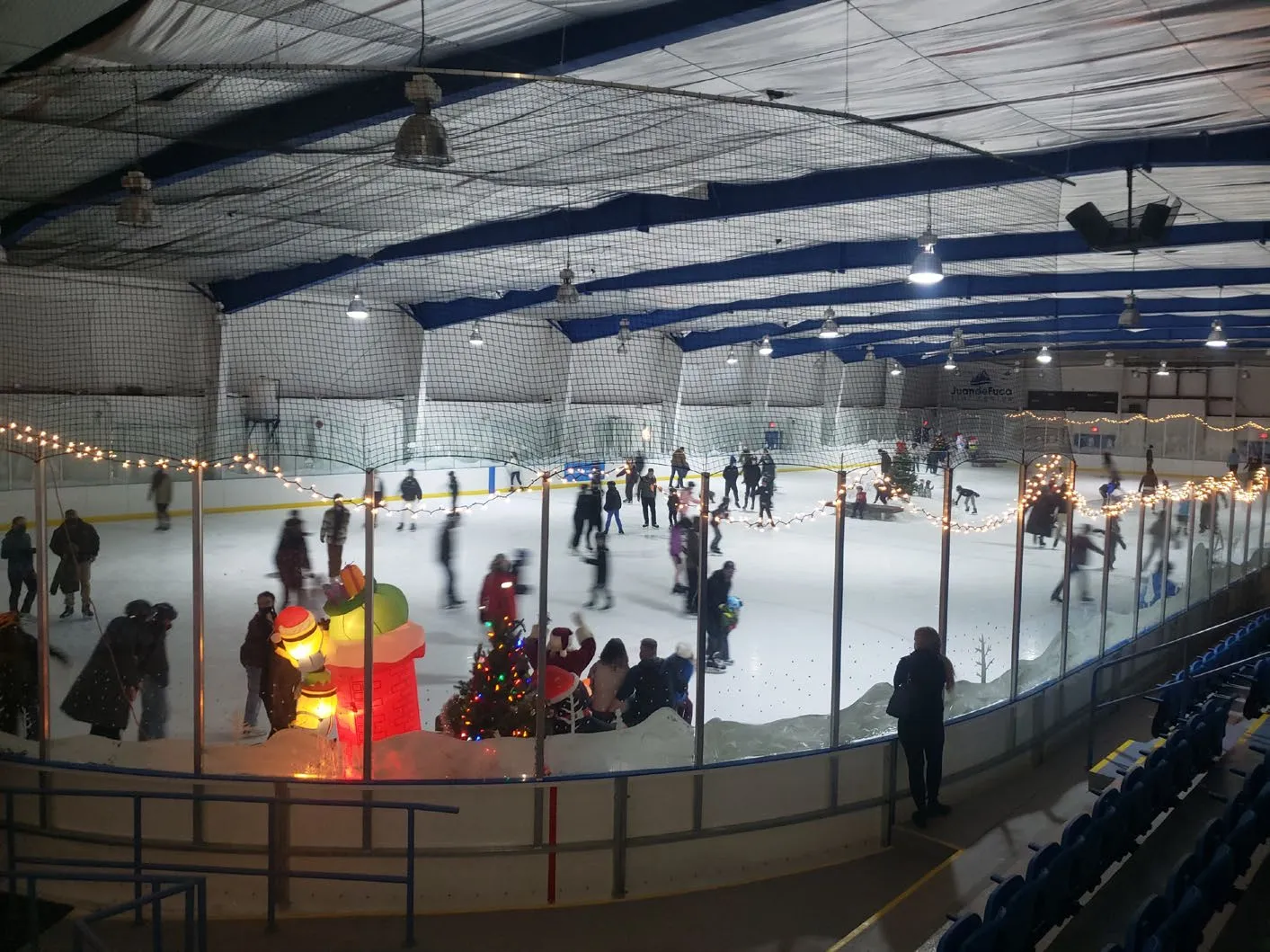 Interior view of the JDF Arena ice rink with skaters and holiday decorations