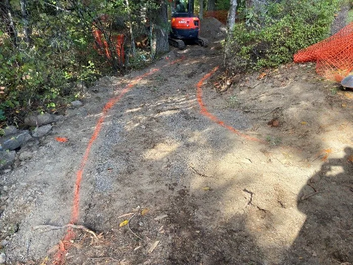 Excavator and orange spray paint markings at Knollwood Park entrance