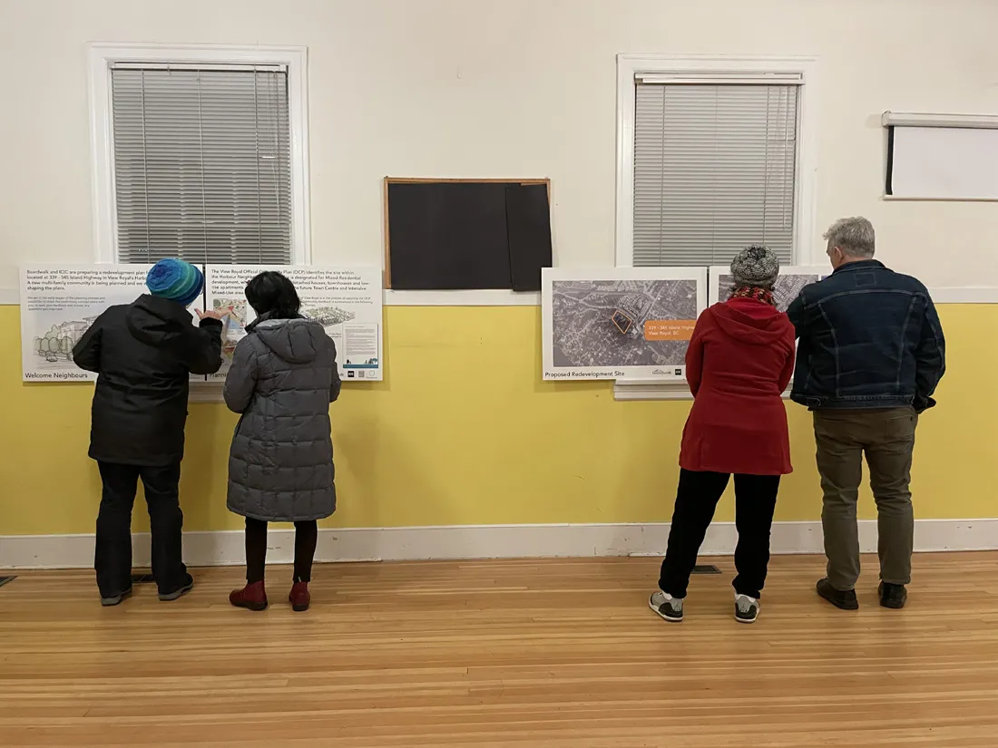 Community members examining detailed site layouts and building elevations at the June 2023 session.