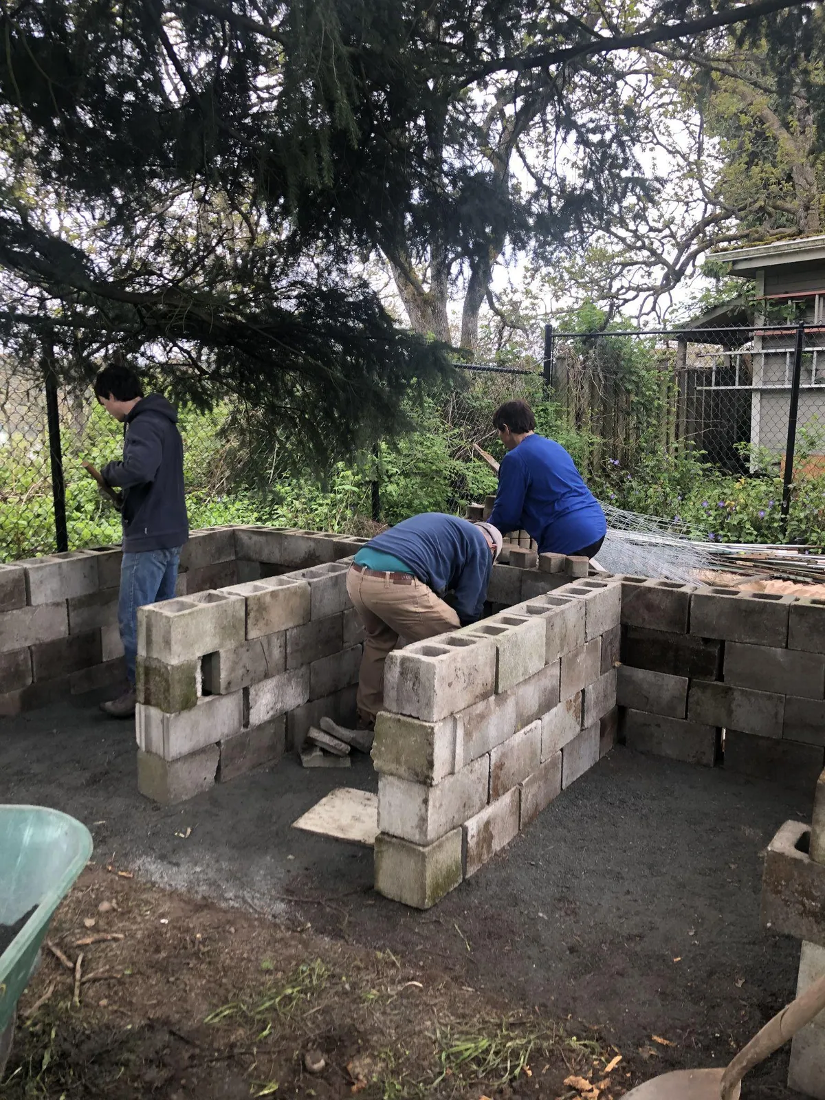 Volunteers building a three-bin compost system using cinder blocks.