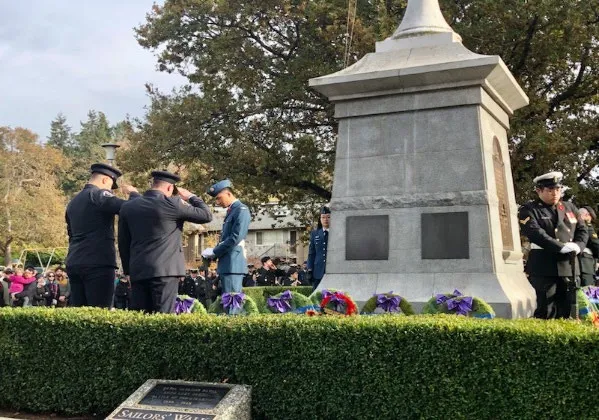 Members saluting at the memorial monument