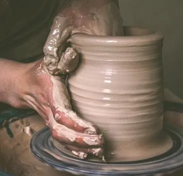 Close-up of hands shaping clay on a pottery wheel