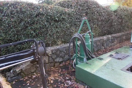 Photo of temporary backup pump equipment installed near a stone wall