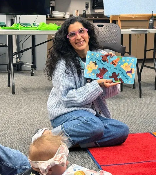 Library staff member showing a board book to a baby