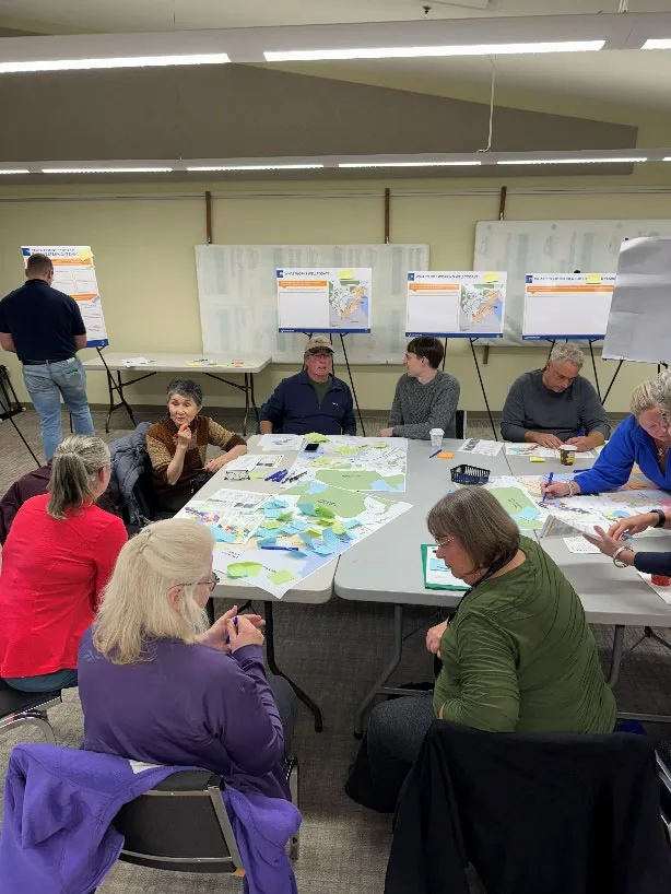 Community members participating in a workshop at tables with maps
