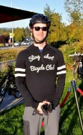 A cyclist wearing a Sling shot Bicycle Club jersey