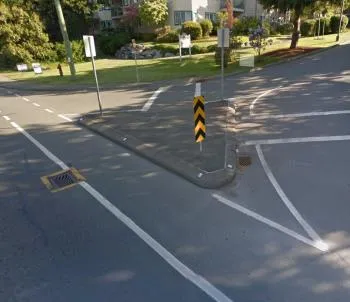 A curb choker at a street entry narrowing the available roadway width.