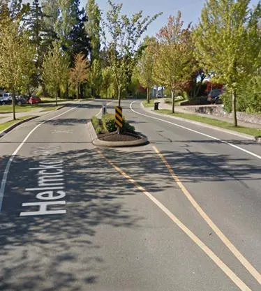A small concrete median island at the entry/exit point of a side street.