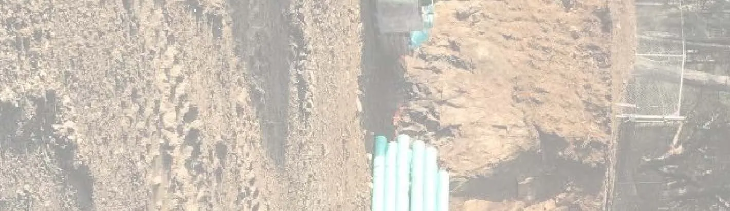 Site photograph fragment showing utility pipes along the wall base