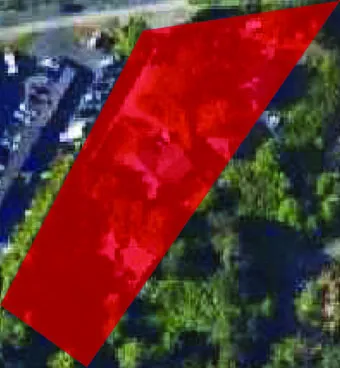 Close-up satellite image highlighting the red-shaded development site boundary