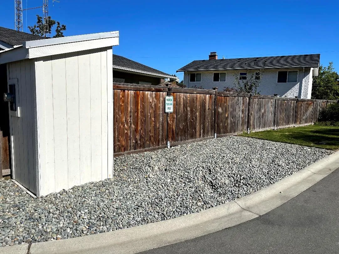 Designated off-street visitor parking area surfaced with gravel and marked with a sign