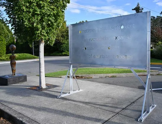 Conceptual public art installation featuring text on a large metal board
