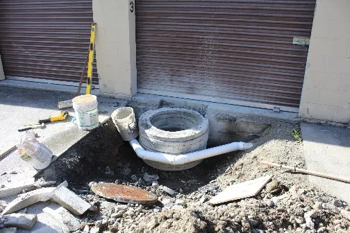 Building foundation notched to allow access to the sewer manhole and rerouting of perimeter drain