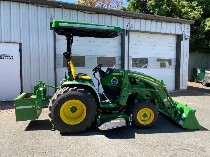 Side view of the new 2021 John Deere tractor with loader and rear attachments