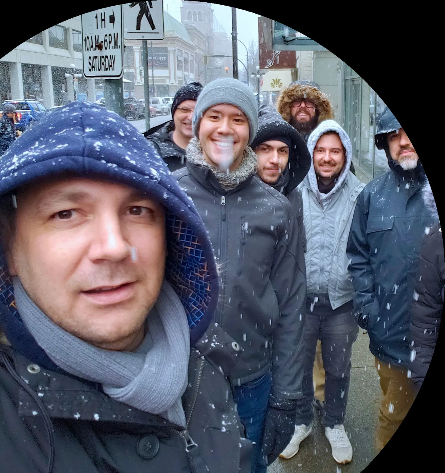 Group of men standing outdoors in falling snow