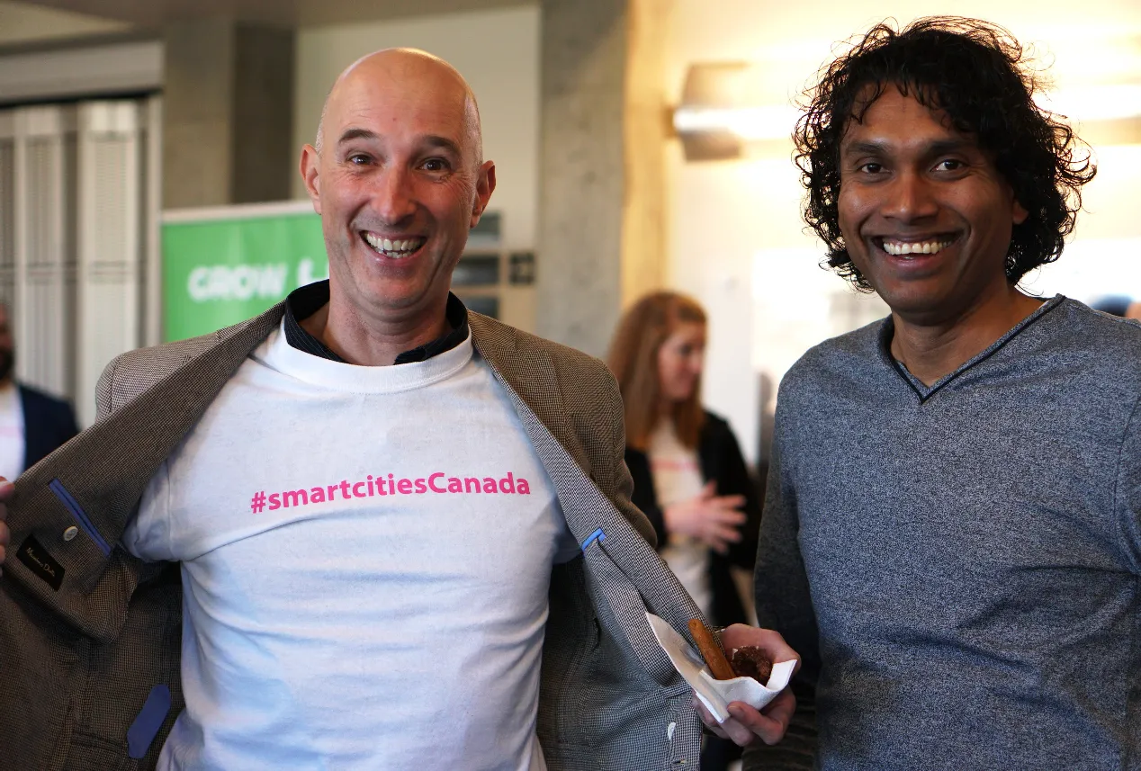Two men smiling, one wearing a t-shirt that says "#smartcitiesCanada"