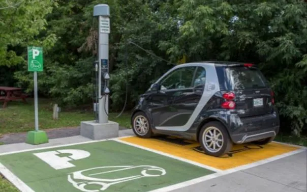 Photograph of a Smart car utilizing an EV charging station