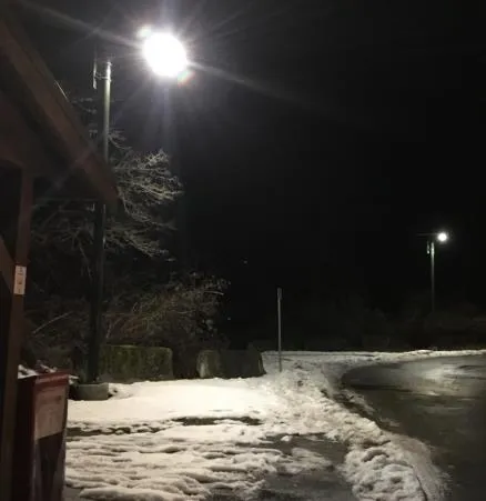 Solar lighting illuminating Highland Road at night in snowy conditions