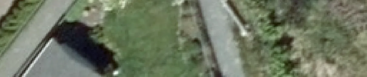 Aerial view crop showing a driveway and part of a car